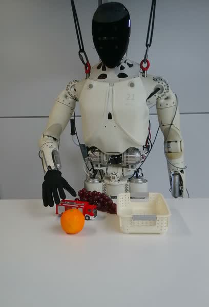 XPENG IronMind humanoid robot reaching toward a toy car and basket during a manipulation demonstration.
