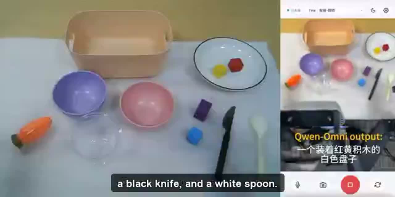 Qwen robot preparing a small colored object on a table in an official manipulation demonstration.